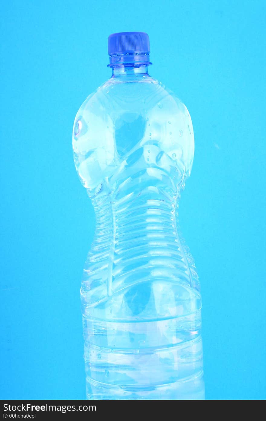 Mineral water pouring from a blue bottle