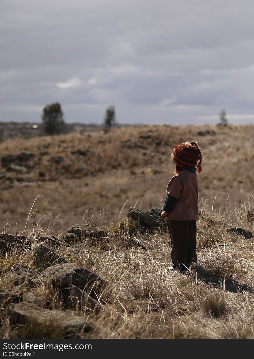 A little boy ponders the land around him trying to determine the best way to go home. A little boy ponders the land around him trying to determine the best way to go home.