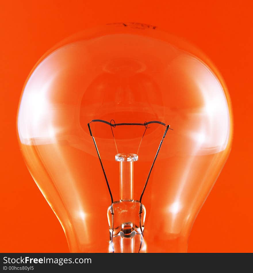 Close-up of a clear light bulb on a red background. Close-up of a clear light bulb on a red background