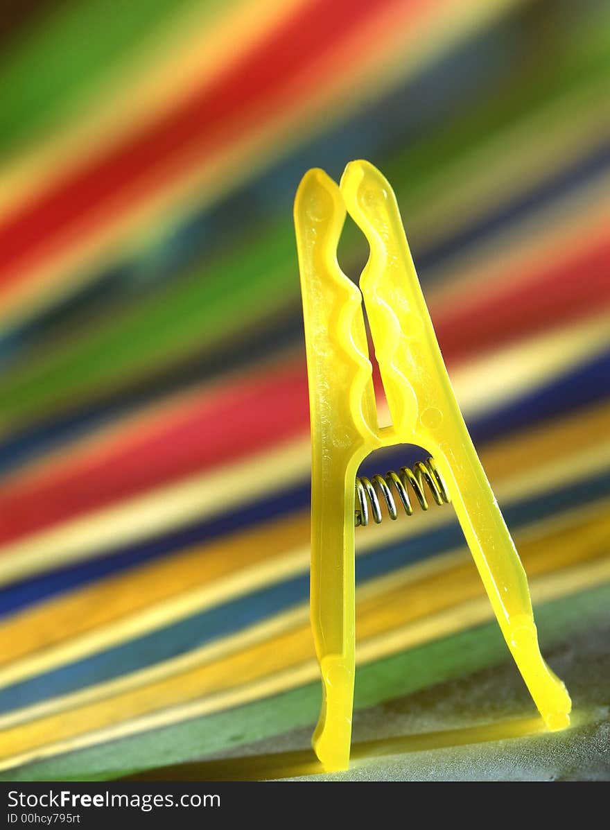 Clothespin of yellow color on a color background