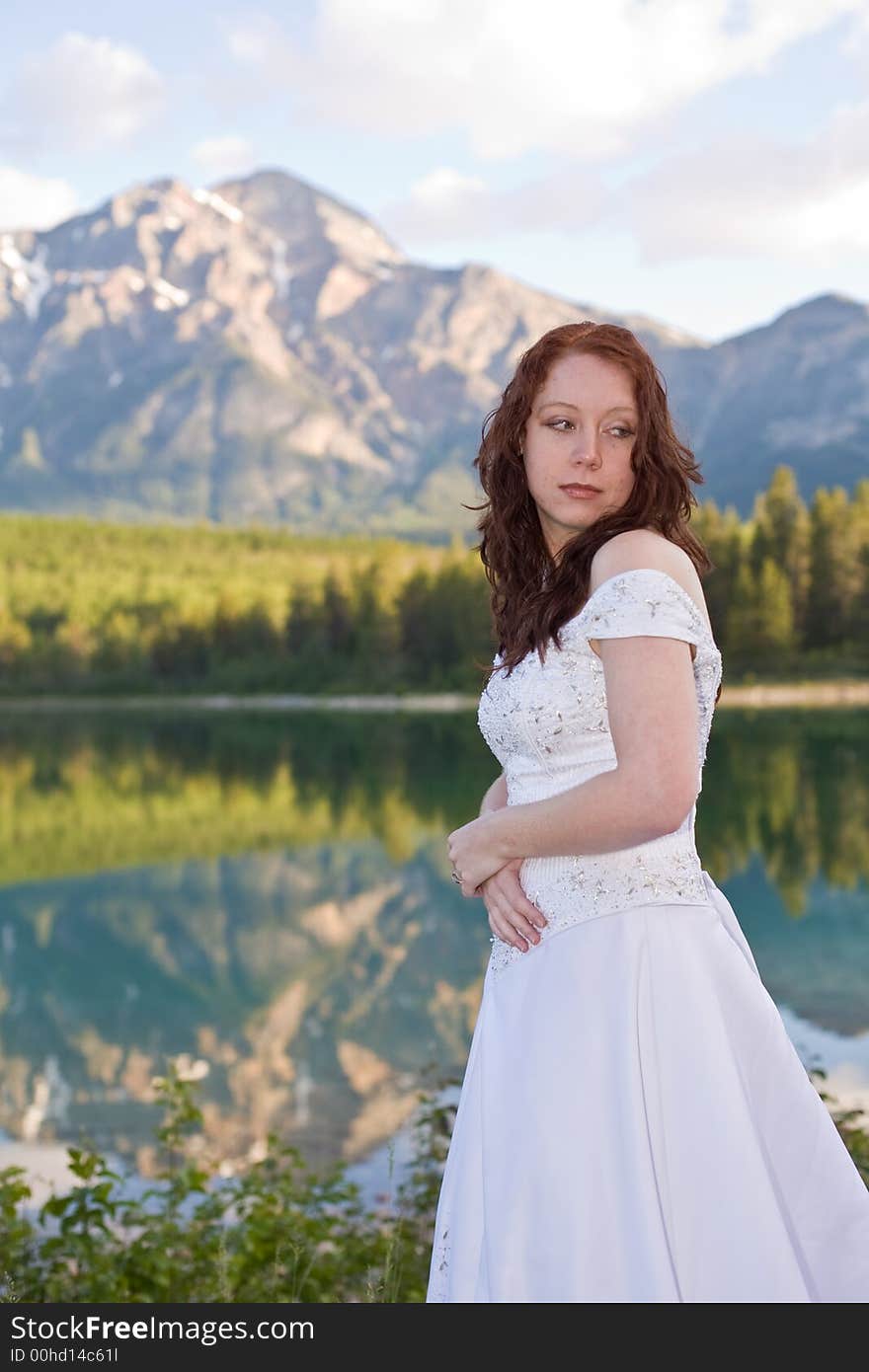 A newly married bride poses for a portrait at Patricia Lake in Jasper National Park, Canada. A newly married bride poses for a portrait at Patricia Lake in Jasper National Park, Canada.