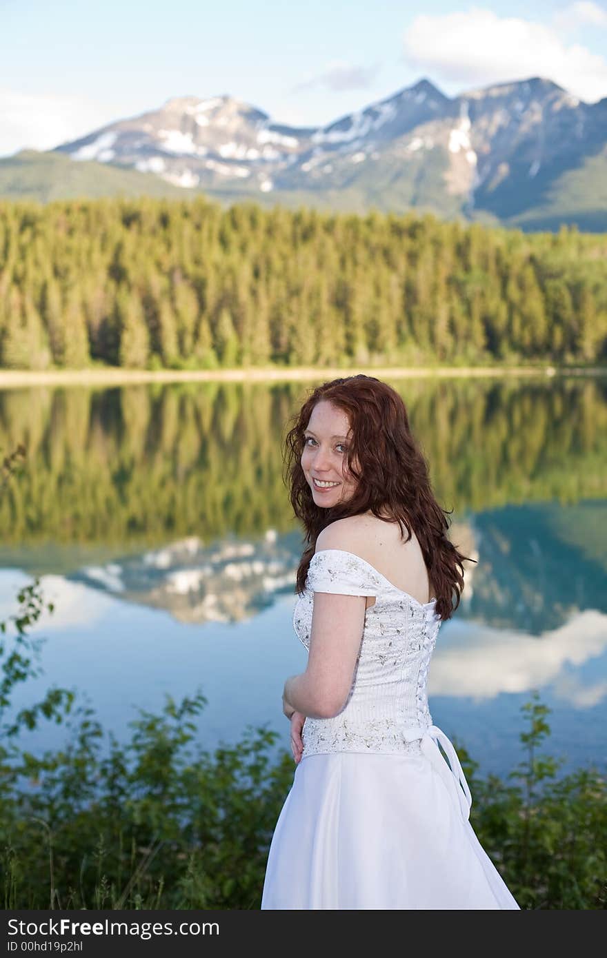 A newly married bride poses for a portrait at Patricia Lake in Jasper National Park, Canada. A newly married bride poses for a portrait at Patricia Lake in Jasper National Park, Canada.