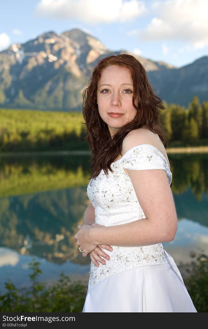 A newly married bride poses for a portrait at Patricia Lake in Jasper National Park, Canada. A newly married bride poses for a portrait at Patricia Lake in Jasper National Park, Canada.