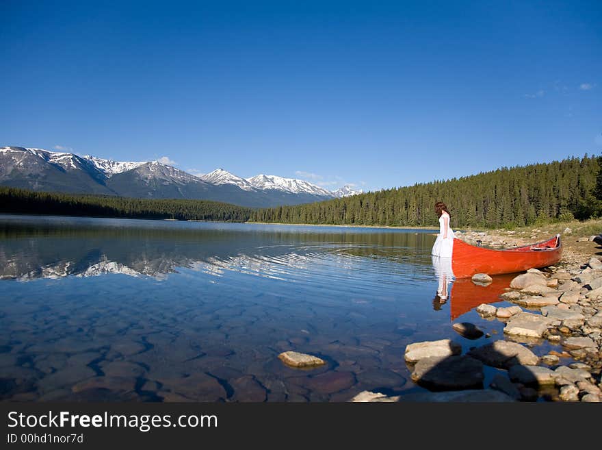 A newly married bride enjoys the waters of Patricia Lake in Jasper National Park, Canada. A newly married bride enjoys the waters of Patricia Lake in Jasper National Park, Canada.