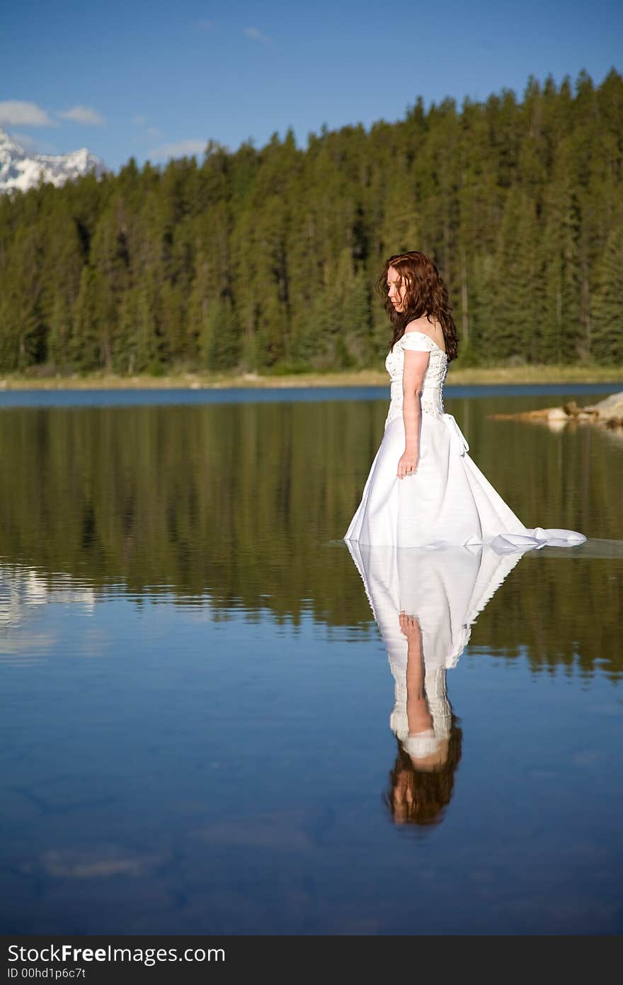 A newly married bride enjoys the waters of Patricia Lake in Jasper National Park, Canada. A newly married bride enjoys the waters of Patricia Lake in Jasper National Park, Canada.