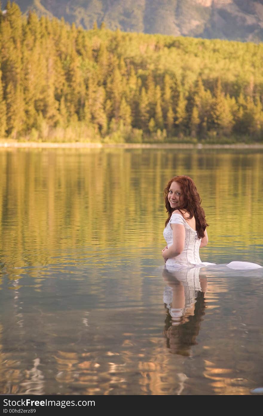 A newly married bride enjoys the waters of Patricia Lake in Jasper National Park, Canada. A newly married bride enjoys the waters of Patricia Lake in Jasper National Park, Canada.