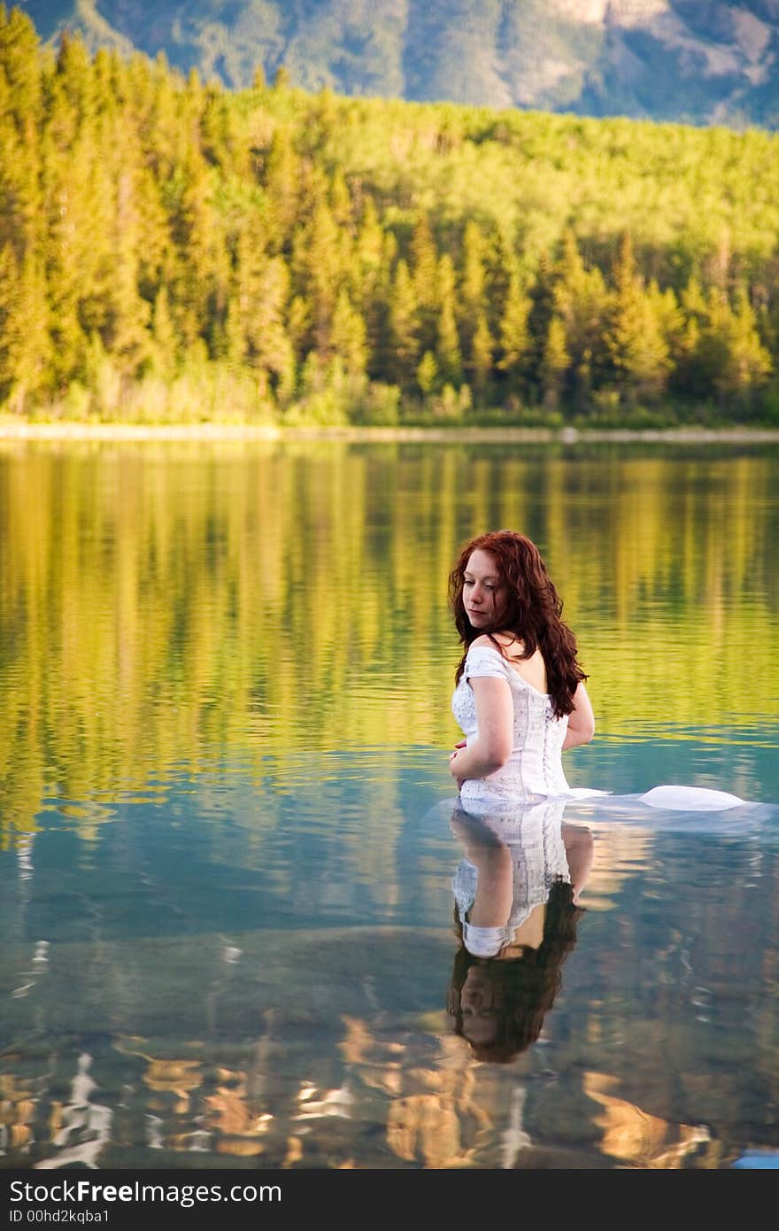 A newly married bride enjoys the waters of Patricia Lake in Jasper National Park, Canada. A newly married bride enjoys the waters of Patricia Lake in Jasper National Park, Canada.