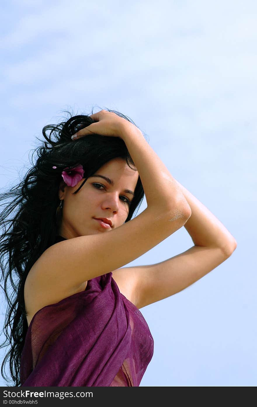 Young tropical girl portrait on blue sky background. Young tropical girl portrait on blue sky background