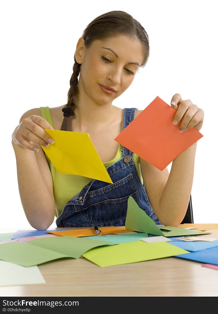 Young, beautiful woman sitting at desk. Holding envelopes and reading something. Front view. White background. Young, beautiful woman sitting at desk. Holding envelopes and reading something. Front view. White background