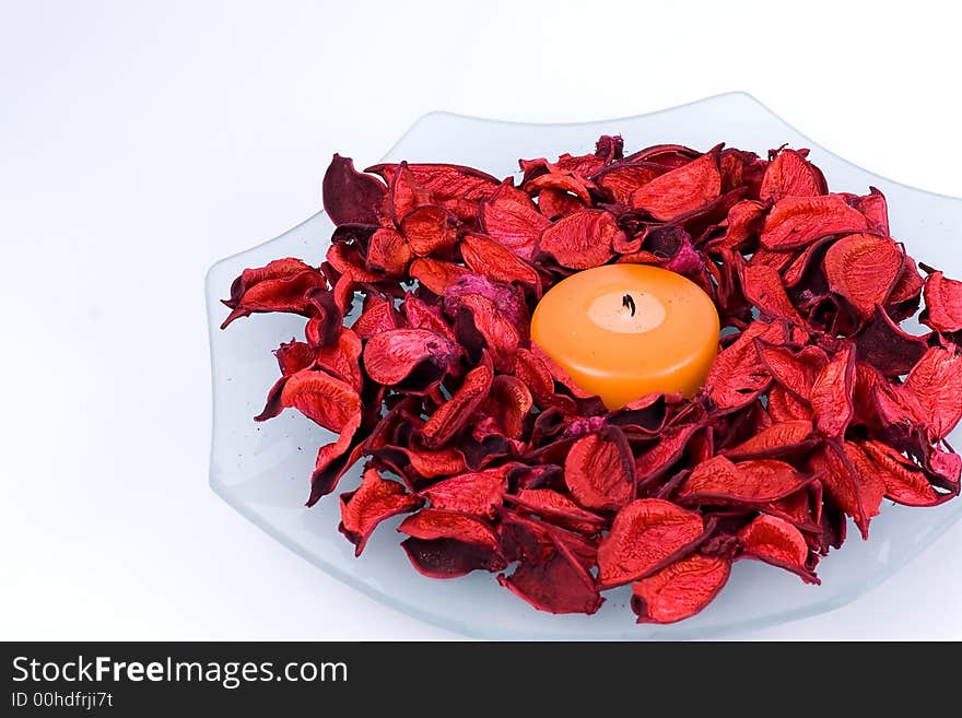 Glass plate with candle and potpourri on the white background. Glass plate with candle and potpourri on the white background