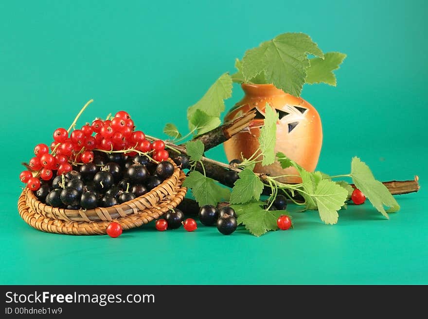 Berries of a red and black currant in a cover and a vase with leaves. Berries of a red and black currant in a cover and a vase with leaves.