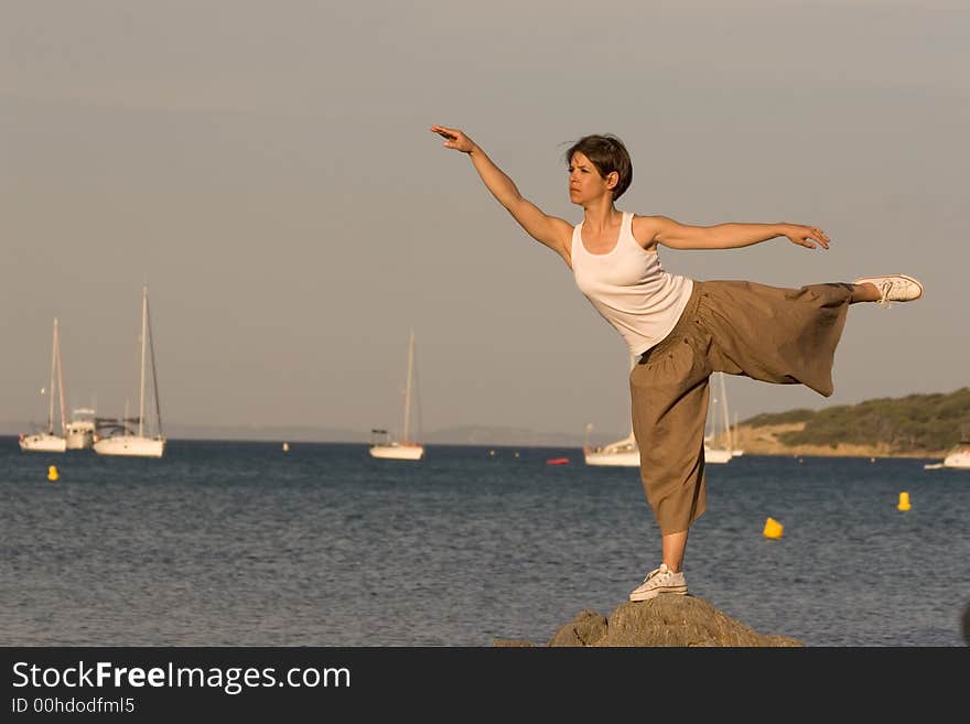 Woman making a exercise of balance at the seaside. Woman making a exercise of balance at the seaside