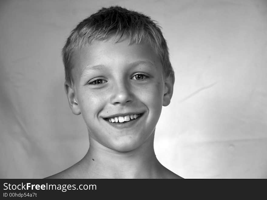 Portrait of young boy smiling in black and white