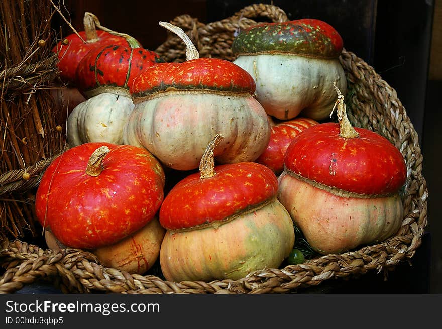 An ornamental basket with  seven pumpkins. An ornamental basket with  seven pumpkins