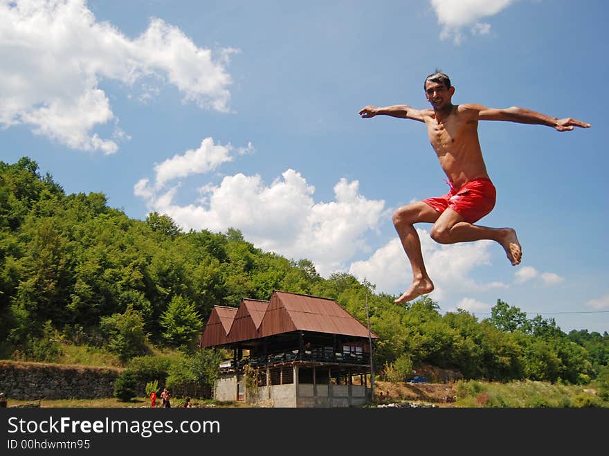 Man jumping in green river. Man jumping in green river