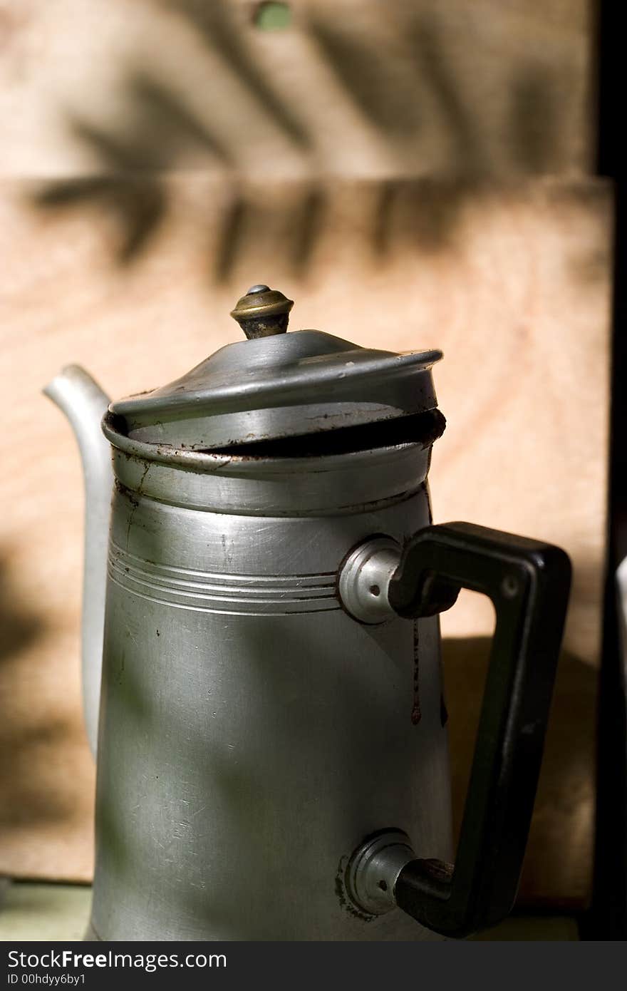 Old rusty coffee pot in the rays of sun. Old rusty coffee pot in the rays of sun