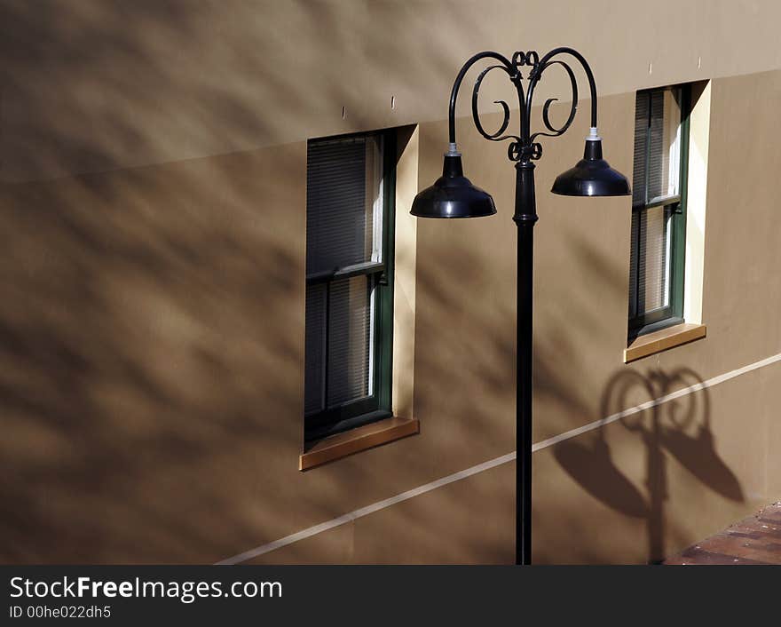 Classic Black Street Light In Front Of A House Wall, Shadows, Windows. Classic Black Street Light In Front Of A House Wall, Shadows, Windows