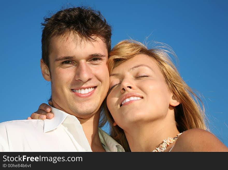 Woman embraces the man against a blue sky. Woman embraces the man against a blue sky