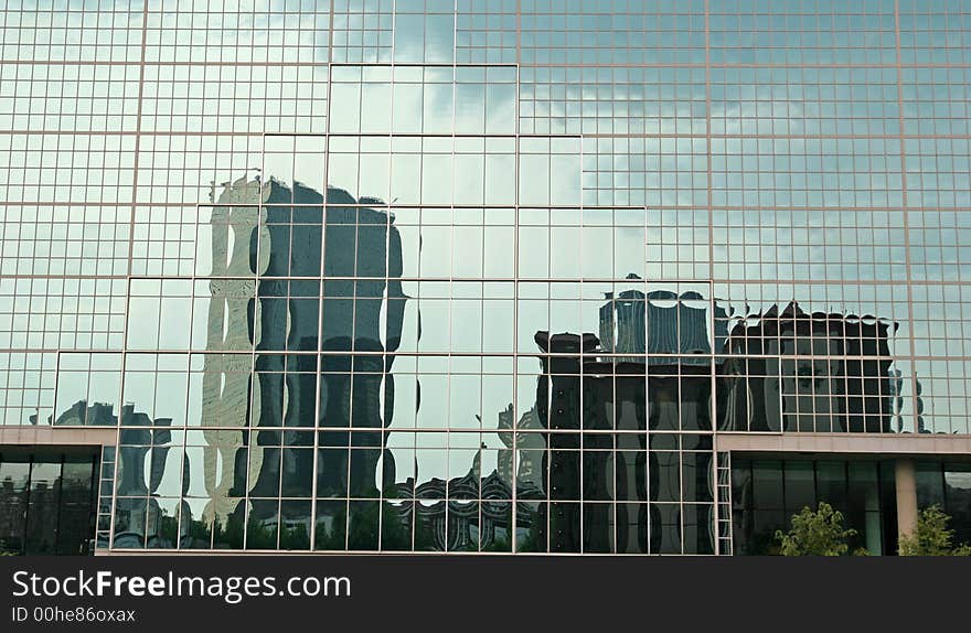 Office buildings reflected in a blue glass building. Office buildings reflected in a blue glass building