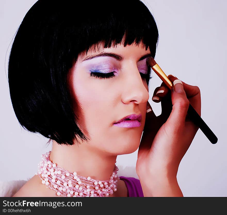 Portrait of a beautiful brunette woman being made up by make-up artist. Portrait of a beautiful brunette woman being made up by make-up artist