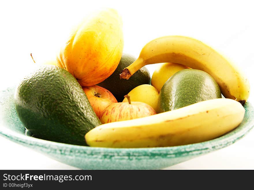 Green bowl of fresh fruit on a white background
