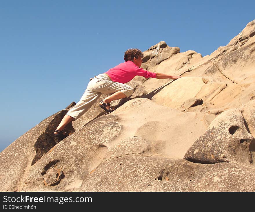 Young Woman climbing a rock wall. Young Woman climbing a rock wall