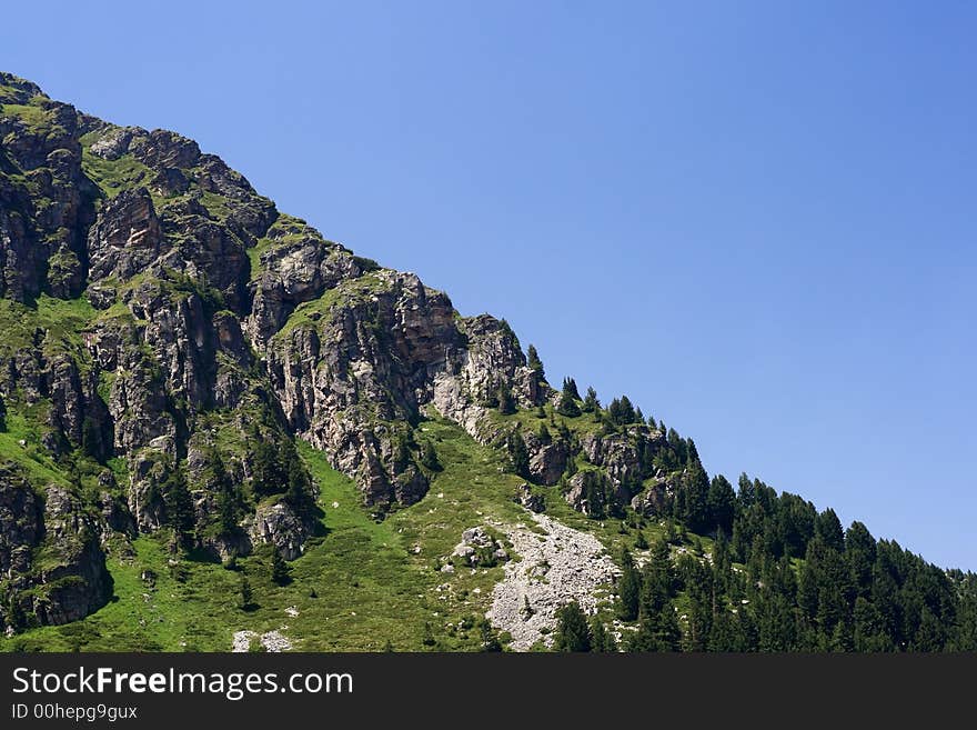 Mountain scenery with forest and rocky slopes. Mountain scenery with forest and rocky slopes