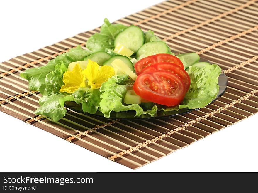 A plate with salad on a wooden napkin . A plate with salad on a wooden napkin .