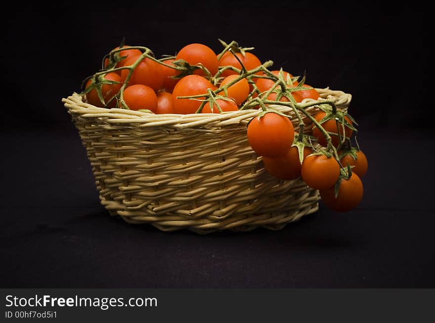 A shoot of pachino's tomato, typical sicily tomato in a basket. A shoot of pachino's tomato, typical sicily tomato in a basket