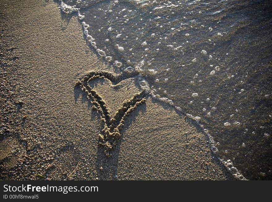 Heart drawn in the sand, beach and water. Heart drawn in the sand, beach and water