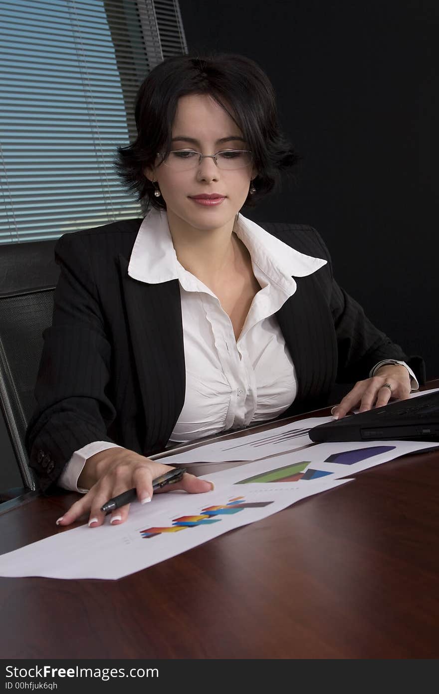 Attractive brunette business woman working at her desk