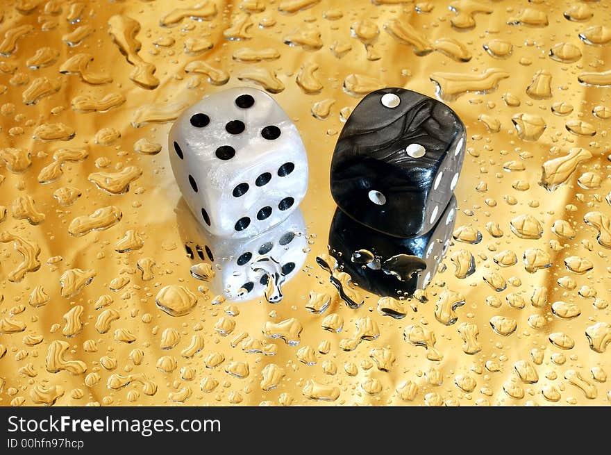 Dice on golden droplets background showing seven points. Dice on golden droplets background showing seven points