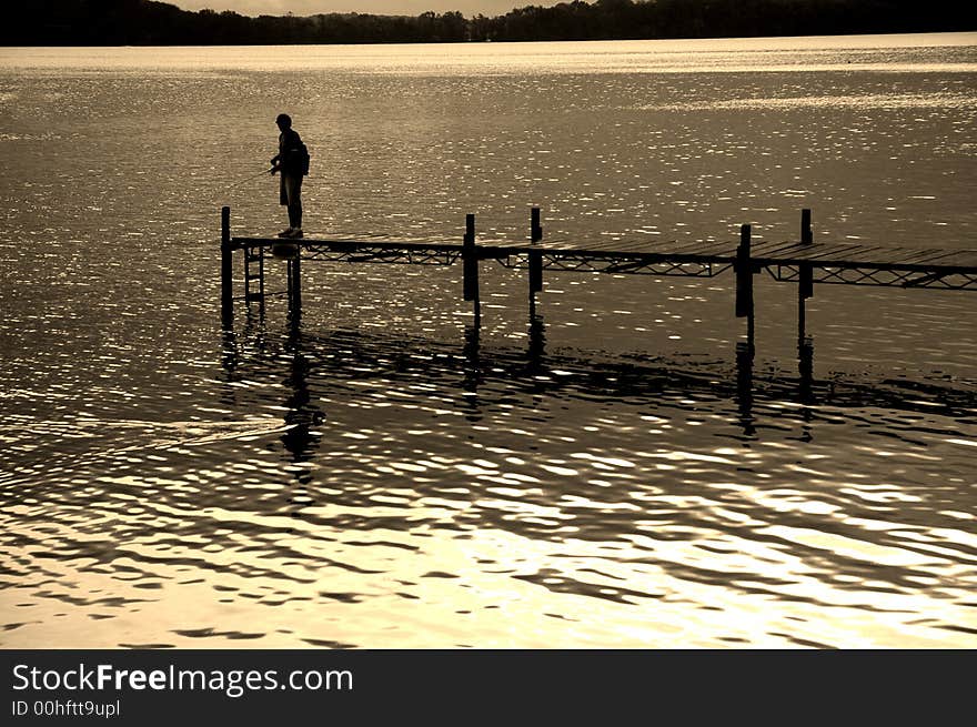 Dock floating in lake with sky and fisherman. Dock floating in lake with sky and fisherman