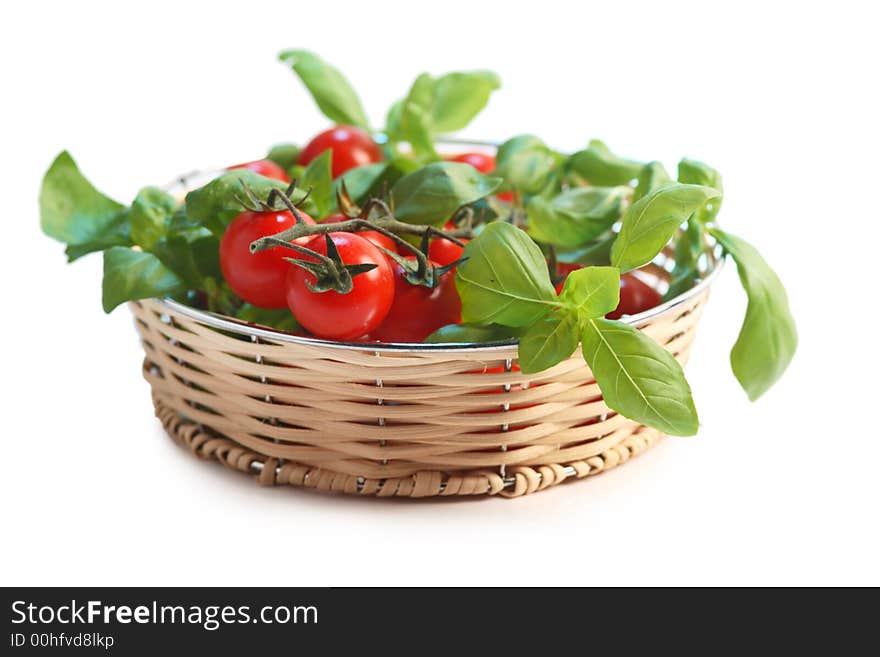 Cherry tomatoes and basil in a wicker basket