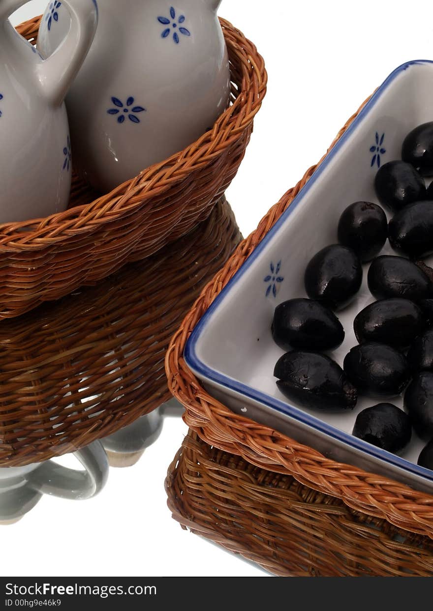 Olives in a ceramic dish in a basket, with oil jugs. Olives in a ceramic dish in a basket, with oil jugs