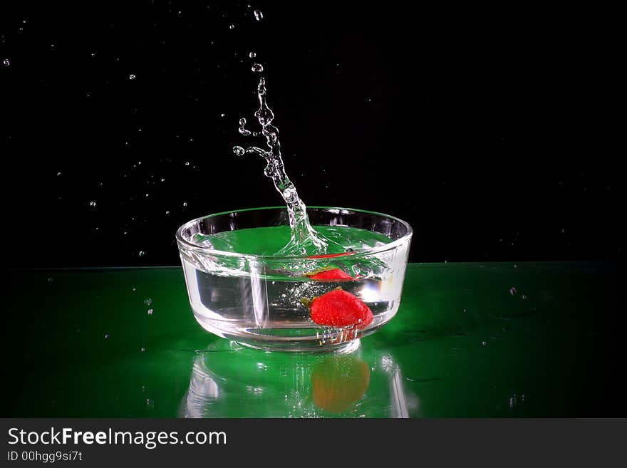 The fruits splash into glass of water. The fruits splash into glass of water