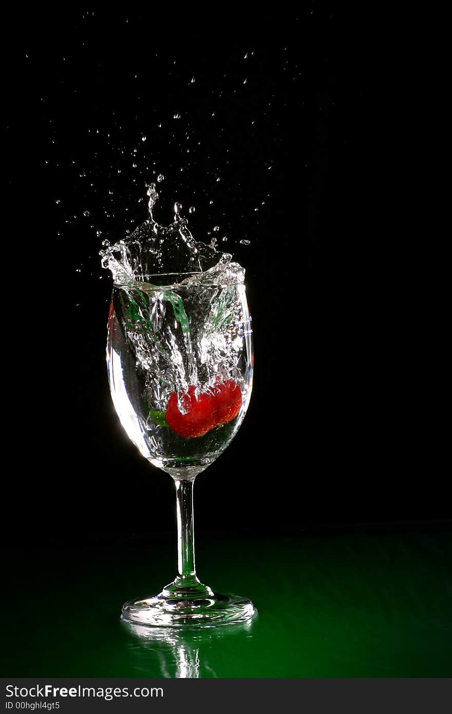 The fruits splash into glass of water. The fruits splash into glass of water