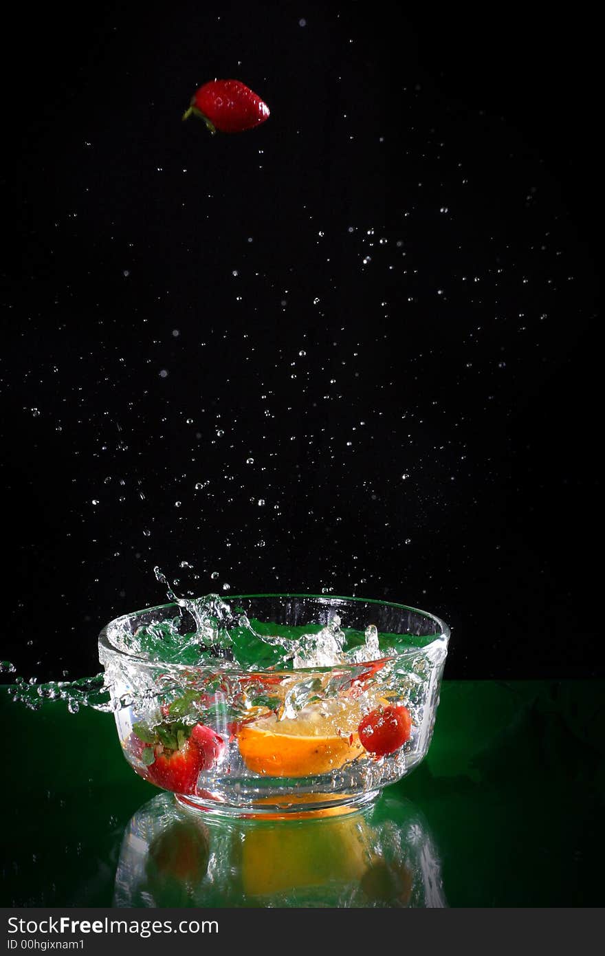 The fruits splash into glass of water. The fruits splash into glass of water