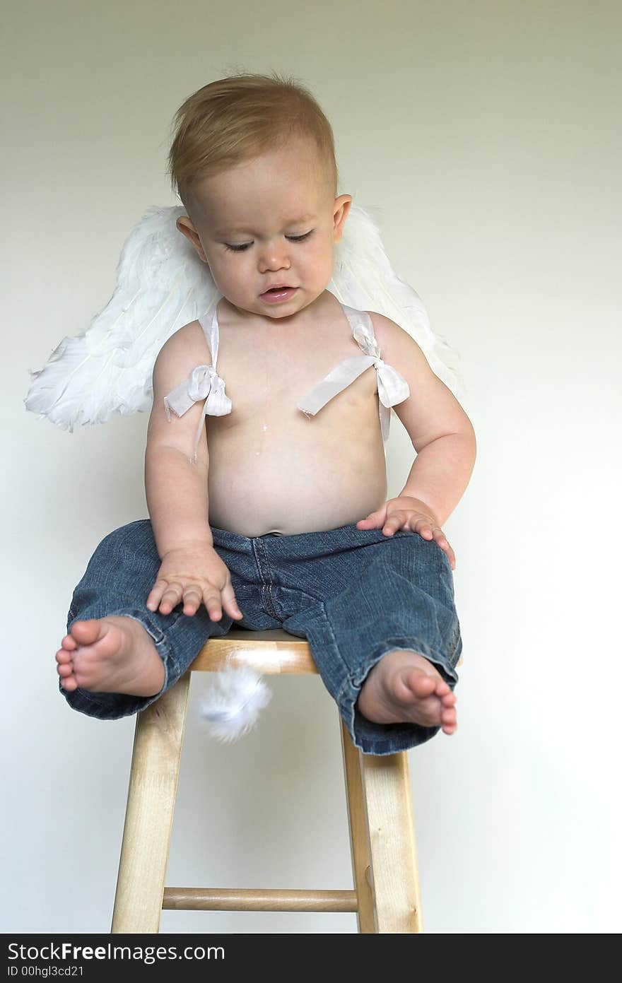 Image of an adorable toddler wearing angel wings and jeans. Image of an adorable toddler wearing angel wings and jeans