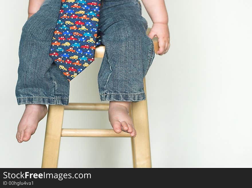 Image of toddler, only visible from the waist down, wearing jeans and a tie. Image of toddler, only visible from the waist down, wearing jeans and a tie