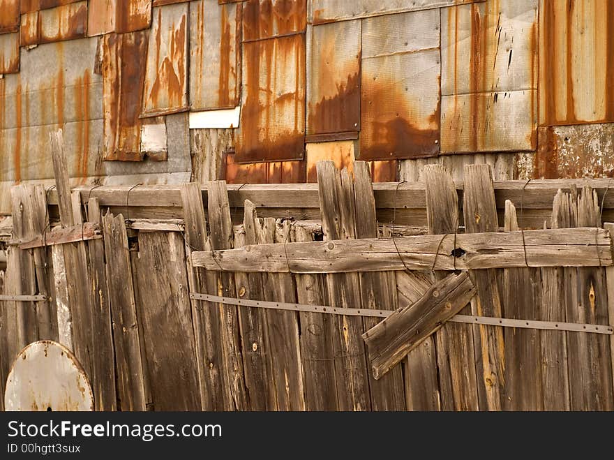 Old wooden fence against steel wall background. Old wooden fence against steel wall background