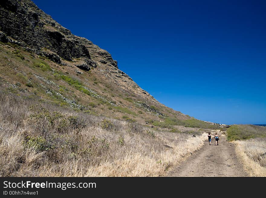 Two girls hiking toward Ka'ena Point