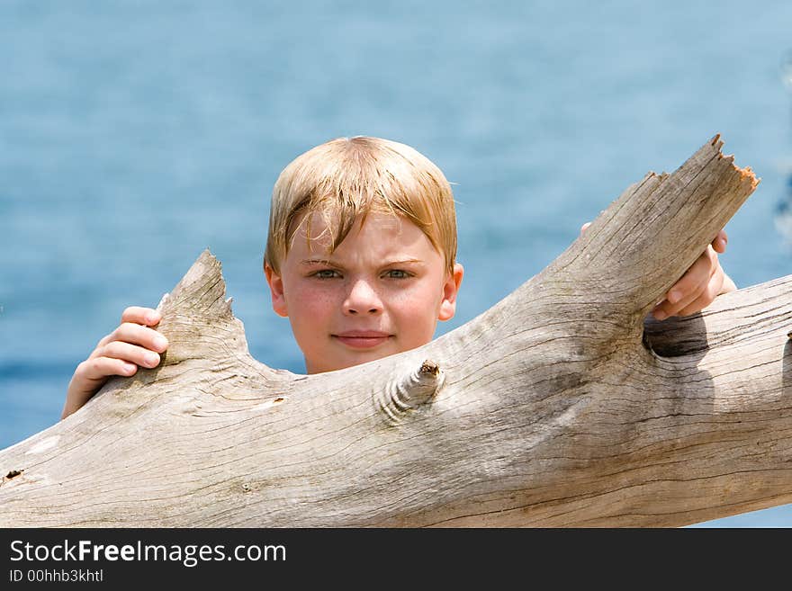 Boy looking over driftwood