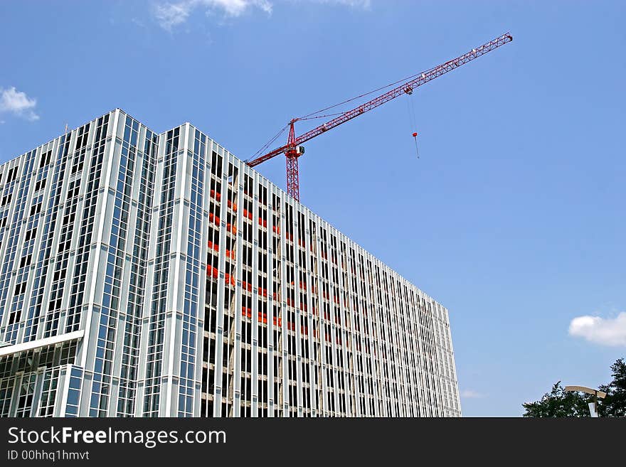 Steel construction tower with red crane on top. Steel construction tower with red crane on top