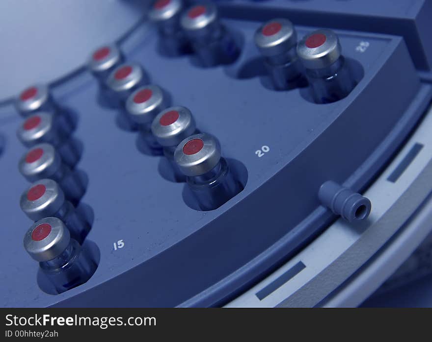 Capped vials on an analysis autosampler - selective focus. Capped vials on an analysis autosampler - selective focus