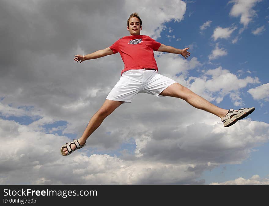 Young man happily jumping against blue sky. Young man happily jumping against blue sky.