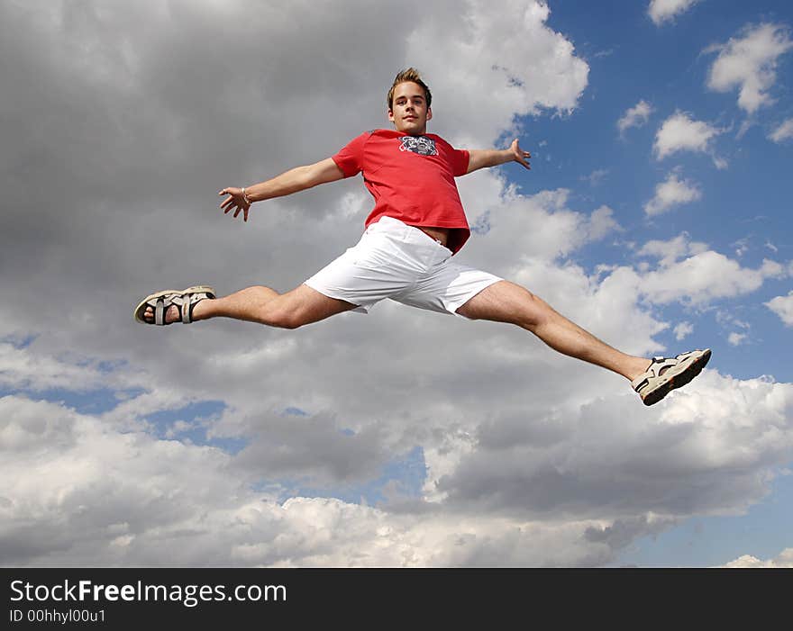 Young man happily jumping against blue sky. Young man happily jumping against blue sky.