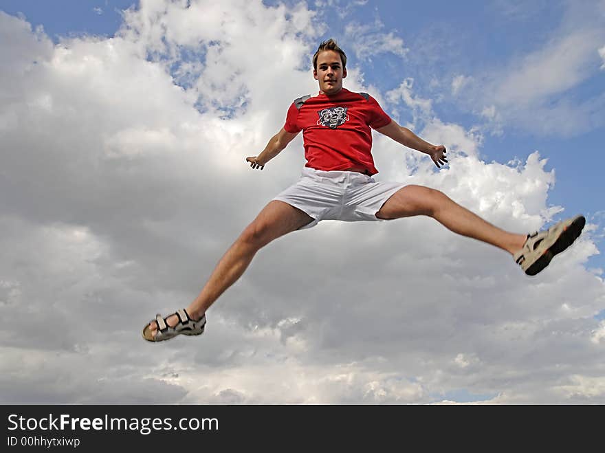 Young man happily jumping against blue sky. Young man happily jumping against blue sky.