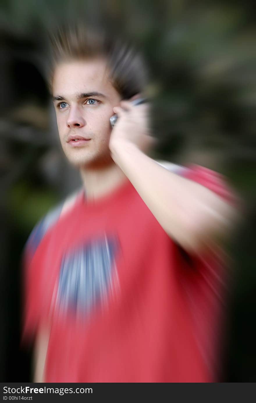 Picture of young leisure time dressed man with cell phone in park talking. Picture of young leisure time dressed man with cell phone in park talking