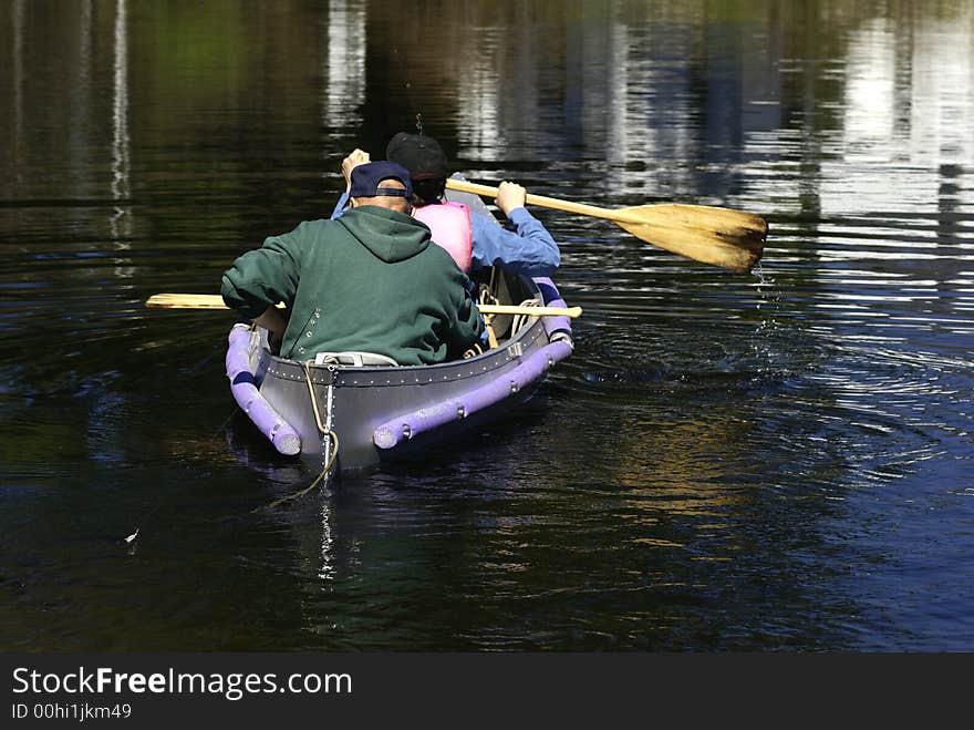 Father and son padding in a canoe. Father and son padding in a canoe